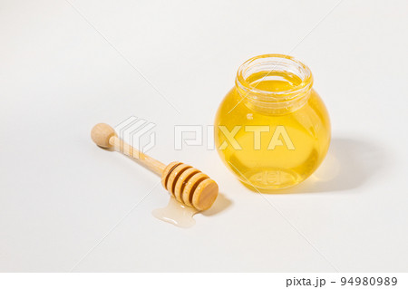 bottled honey and honey dipper stick 94980989