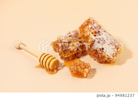 sliced honeycomb and honey dipper stick 94981237