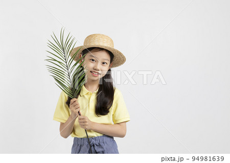 Korean young girl wearing gym clothes in white background studio__holding a tropical leaves Korean young girl wearing gym clothes in white background studio__holding a tropical leaves 94981639