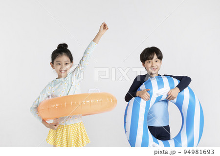 Korean boy and girl, summer concept in white background_holding a inflatable pool float Korean boy and girl, summer concept in white background_holding a inflatable pool float 94981693