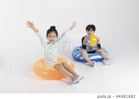 Korean boy and girl, summer concept in white background_sitting on the inflatable pool float Korean boy and girl, summer concept in white background_sitting on the inflatable pool float 94981882