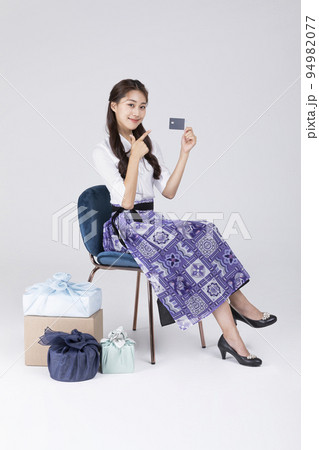 beautiful Korean woman in 20s wearing modern Hanbok_showing credit card 94982077