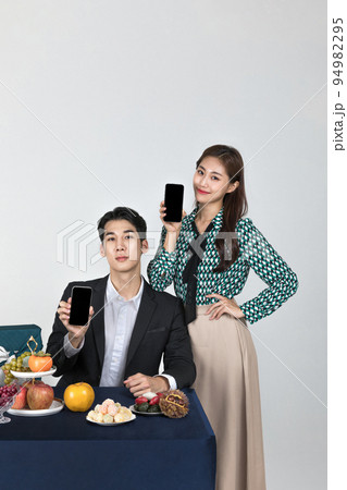 Korean young couple, man and woman wearing modern Hanbok_holding smartphone Korean young couple, man and woman wearing modern Hanbok_holding smartphone 94982295