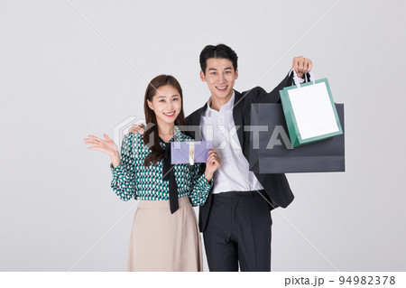 Korean young couple, man and woman wearing modern Hanbok_holding paper bag and Korean traditional wedding clutch, envelope Korean young couple, man and woman wearing modern Hanbok_holding paper bag and Korean traditional wedding clutch, envelope 94982378
