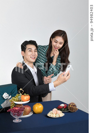 Korean young couple, man and woman wearing modern Hanbok_watching smartphone 94982403