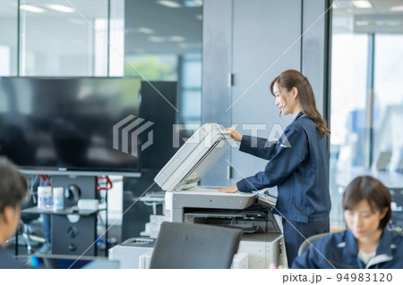 A4用紙をスキャンして、データ化する女性 94983120