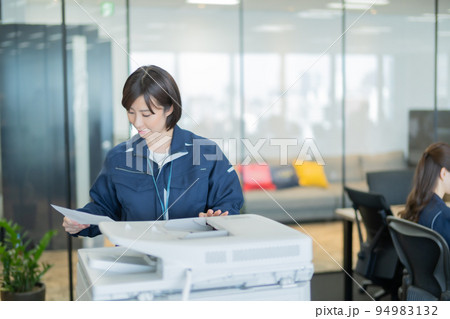 プリントしたドキュメントを確認する若い女性 94983132