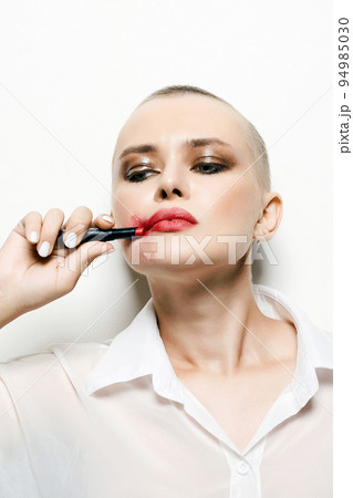 portrait of bald girl with red lipstick on her face. clown 94985030