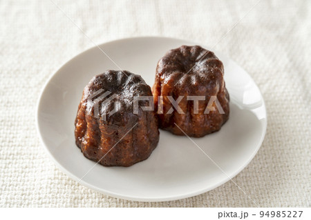 白いお皿にのったフランスの洋菓子カヌレ 94985227
