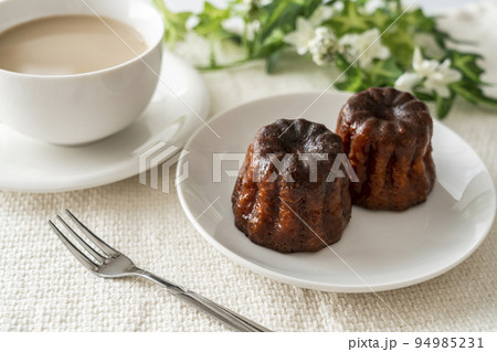 白いお皿にのったフランスの洋菓子カヌレとカフェラテ 白いお皿にのったフランスの洋菓子カヌレとカフェラテ 94985231