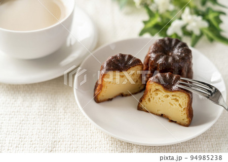 白いお皿にのったフランスの洋菓子カヌレとカフェラテ 白いお皿にのったフランスの洋菓子カヌレとカフェラテ 94985238