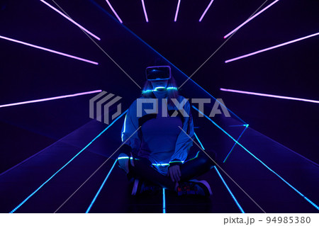 Woman is using virtual reality headset to access in metaverse. 94985380