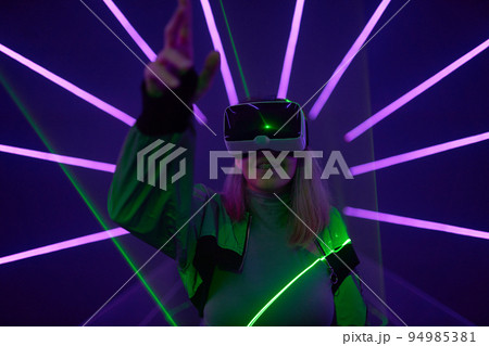 Woman is using virtual reality headset to access in metaverse. 94985381
