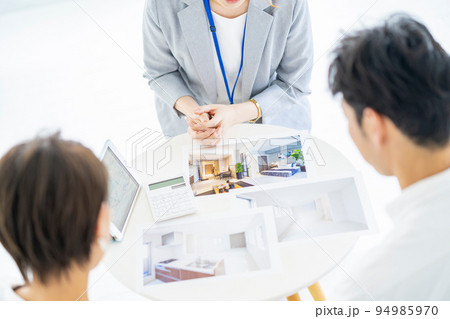 夫婦に不動産を営業するスーツ姿の女性 夫婦に不動産を営業するスーツ姿の女性 94985970