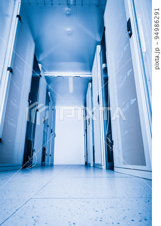 A row of racks with data storage hardware inside server room 94986291