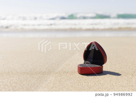 砂浜に置かれたLED付きリングケース　プロポーズイメージ 94986992