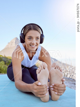 Outdoor yoga, stretching and woman with headphones listening to wellness podcast or calm music for exercise motivation. Sports person in cardio or pilates workout with audio in nature and lens flare 94987074