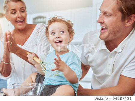 Mother, father and baby baking as a happy family in a kitchen enjoys quality time and the weekend together. Development, learning and mom cheering for her young child with dad and ready to bake cake Mother, father and baby baking as a happy family in a kitchen enjoys quality time and the weekend together. Development, learning and mom cheering for her young child with dad and ready to bake cake 94987451