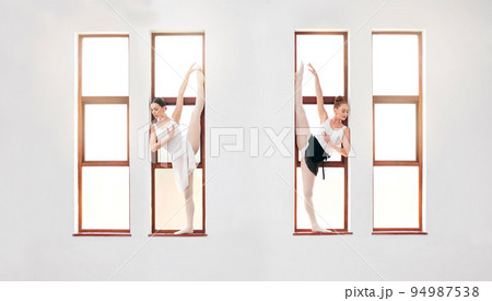 Ballet, art and dancers dancing on the window at the dance academy in a practice studio. Elegant team of ballerinas stretching, training and practicing a skill for classical recital performance. 94987538