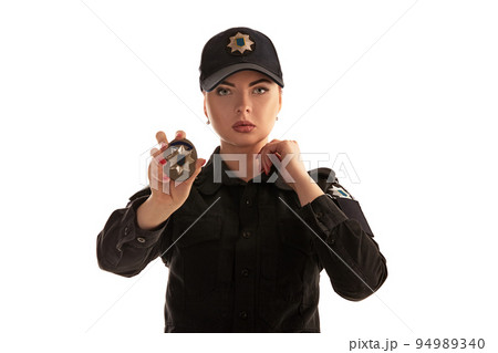 Close-up shot of a redheaded female police officer posing for the camera isolated on white background. 94989340