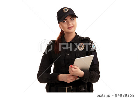 Close-up shot of a redheaded female police officer posing for the camera isolated on white background. 94989358