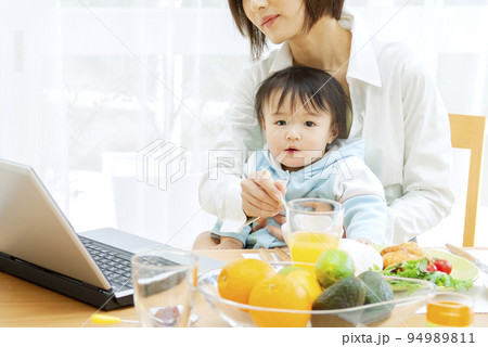 赤ちゃんにご飯を食べさせる母親 赤ちゃんにご飯を食べさせる母親 94989811
