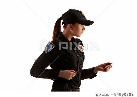Close-up shot of a redheaded female police officer posing for the camera isolated on white background. 94990288