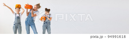 Banner happy halloween and holidays concept - A mother and her daughters with pumpkins. Happy family preparing for Halloween copy space Banner happy halloween and holidays concept - A mother and her daughters with pumpkins. Happy family preparing for Halloween copy space 94991618