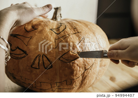 preparation for the holiday. The process of carving a Halloween pumpkin on the table preparation for the holiday. The process of carving a Halloween pumpkin on the table 94994407