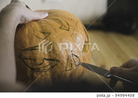 preparation for the holiday. The process of carving a Halloween pumpkin on the table 94994408