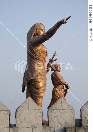 Metal idols of Jijabai and Bal Shivaji at the entrance of Shiv Srushti, a theme park located at Junnar, near Pune, Maharashtra, India 94994581