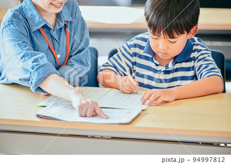 ノートに書き取りをする小学生の男の子 94997812