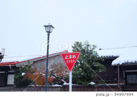 雪降る街の止まれの標識 94997994