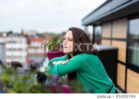 Portrait of an attractive thirty year old white woman posing on a terrace 95000749