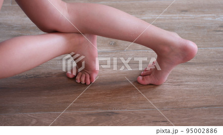 Children feet slide on wooden floor of house closeup Children feet slide on wooden floor of house closeup 95002886