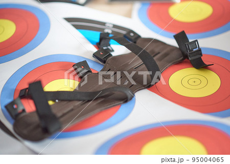 Leather gauntlet for hunting or archery lies on a pack of shooting range targets Leather gauntlet for hunting or archery lies on a pack of shooting range targets 95004065