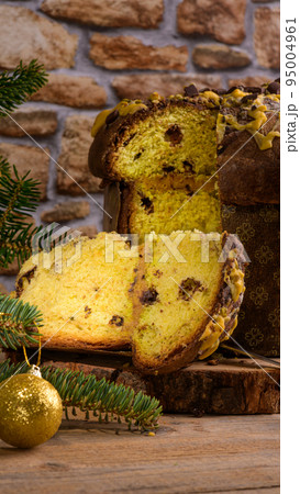 Traditional Italian Christmas Cake Panettone with green bow with cut piece of cake on rustic wooden background 95004961