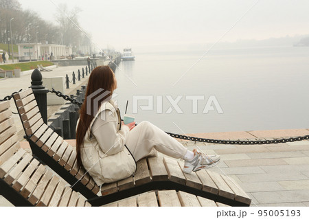 brunette girl with long hair in white jacket full body portrait on foggy landscape background 95005193