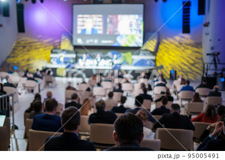 Businesspeople watching online conference in auditorium Businesspeople watching online conference in auditorium 95005491