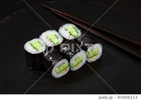 Sushi Maki rolls cucumber. Fresh hosomaki pieces with rice and nori. Close Up of delicious japanese food with sushi roll. Sushi Maki rolls cucumber. Fresh hosomaki pieces with rice and nori. Close Up of delicious japanese food with sushi roll. 95006313
