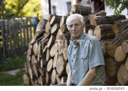 portrait of  senior man sitting in front of his house 95008095