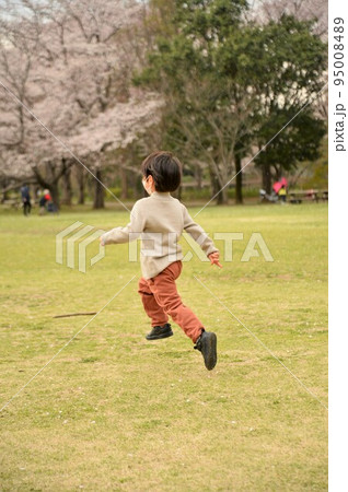春の公園で飛び跳ねる子供 95008489