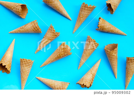 Empty ice cream cone on blue background. 95009302