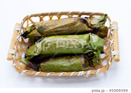 Grilled sticky rice in banana leaves with banana filling Grilled sticky rice in banana leaves with banana filling 95009399