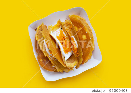 Thai crispy pancakes on yellow background. 95009403