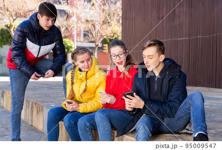 Teenagers hanging out on streets of city Teenagers hanging out on streets of city 95009547