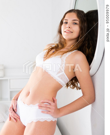 Cute young seductive girl in panties playfully posing in home