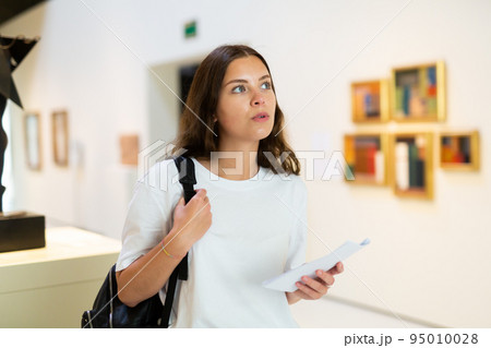 Portrait of a young girl visitor on at the exhibition of paintings in the museum 95010028