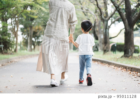 公園の歩道を歩く親子 95011128