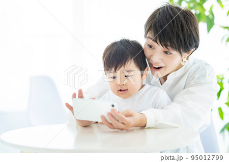 スマートフォンを操作する子供とお母さん  95012799